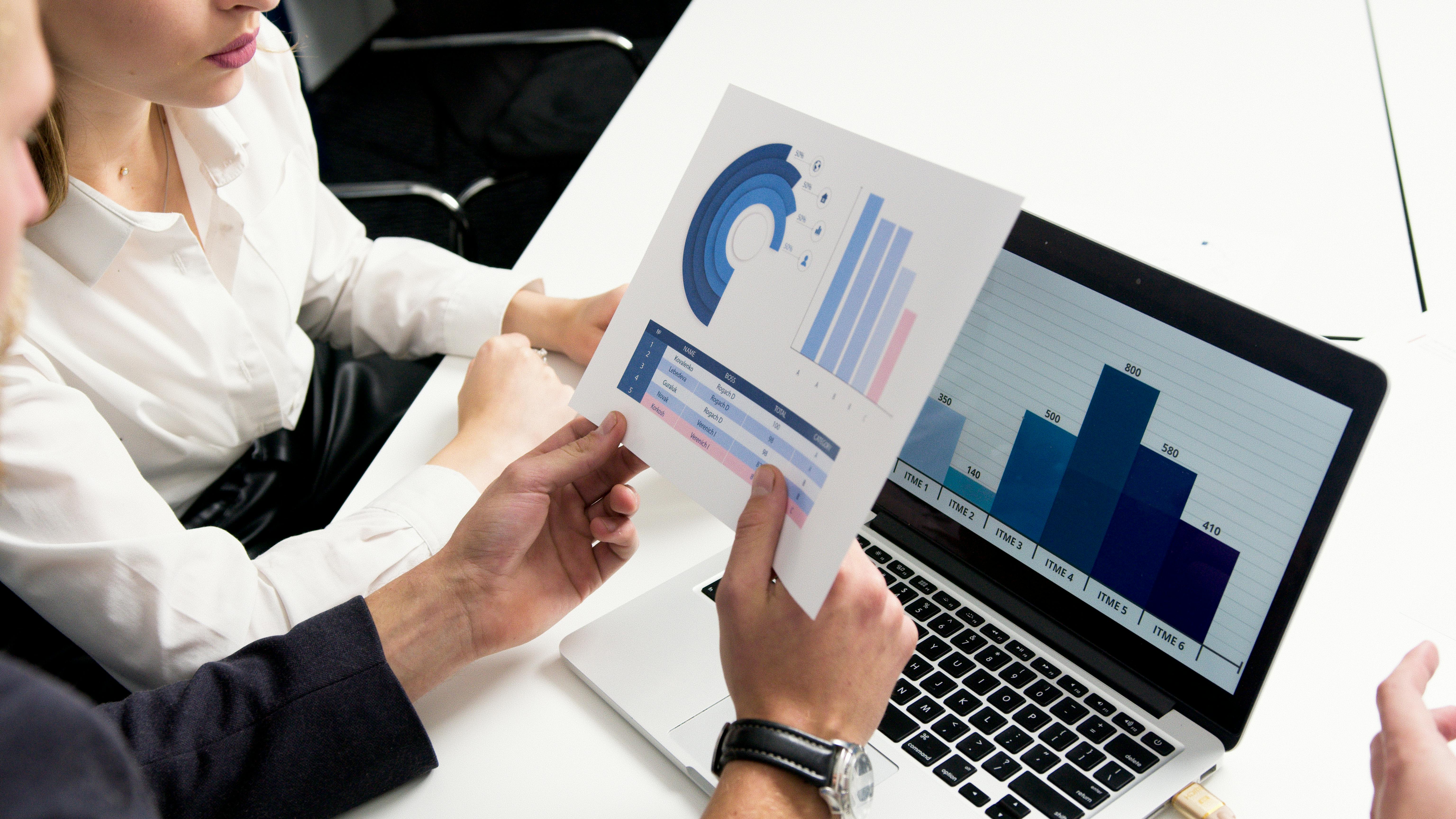 photo of two people looking at a reporting sheet
